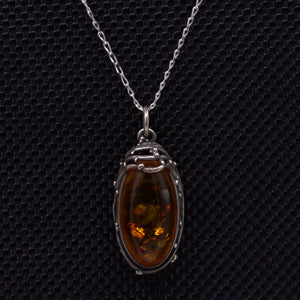 Amber silver pendant featuring wirework and delicate silver balls