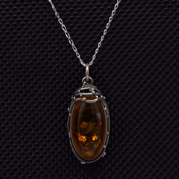 Amber silver pendant featuring wirework and delicate silver balls