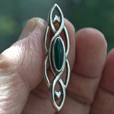 silver Celtic knotwork brooch with green marquise stone