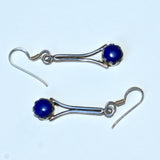Pair of solid silver earrings with Lapis blue stones on a white background