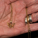 solid gold filigree butterfly necklace shown in hand