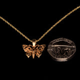 solid gold butterfly pendant next to 20p coin