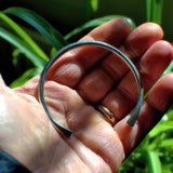 solid silver open torc bangle with flattened ends shown in hand