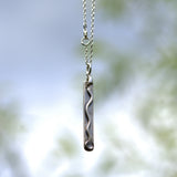 solid silver wave design oblong drop pendant featuring pale blue Sapphire