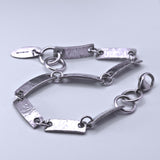 solid silver link bracelet featuring textured oblong links and circular chain links