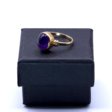 solid 9ct yellow gold ring featuring an Amethyst gemstone, shown on top of gift box
