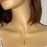 Model wearing a solid 9ct gold necklace with a green Peridot Celtic pendant