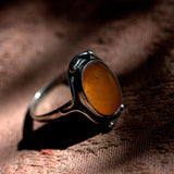 Ring with amber stone on a brown fabric background