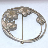 large circular silver nature brooch