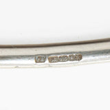 silver curved bangle showing hallmarks