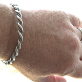 Celtic style silver torc bangle on wrist